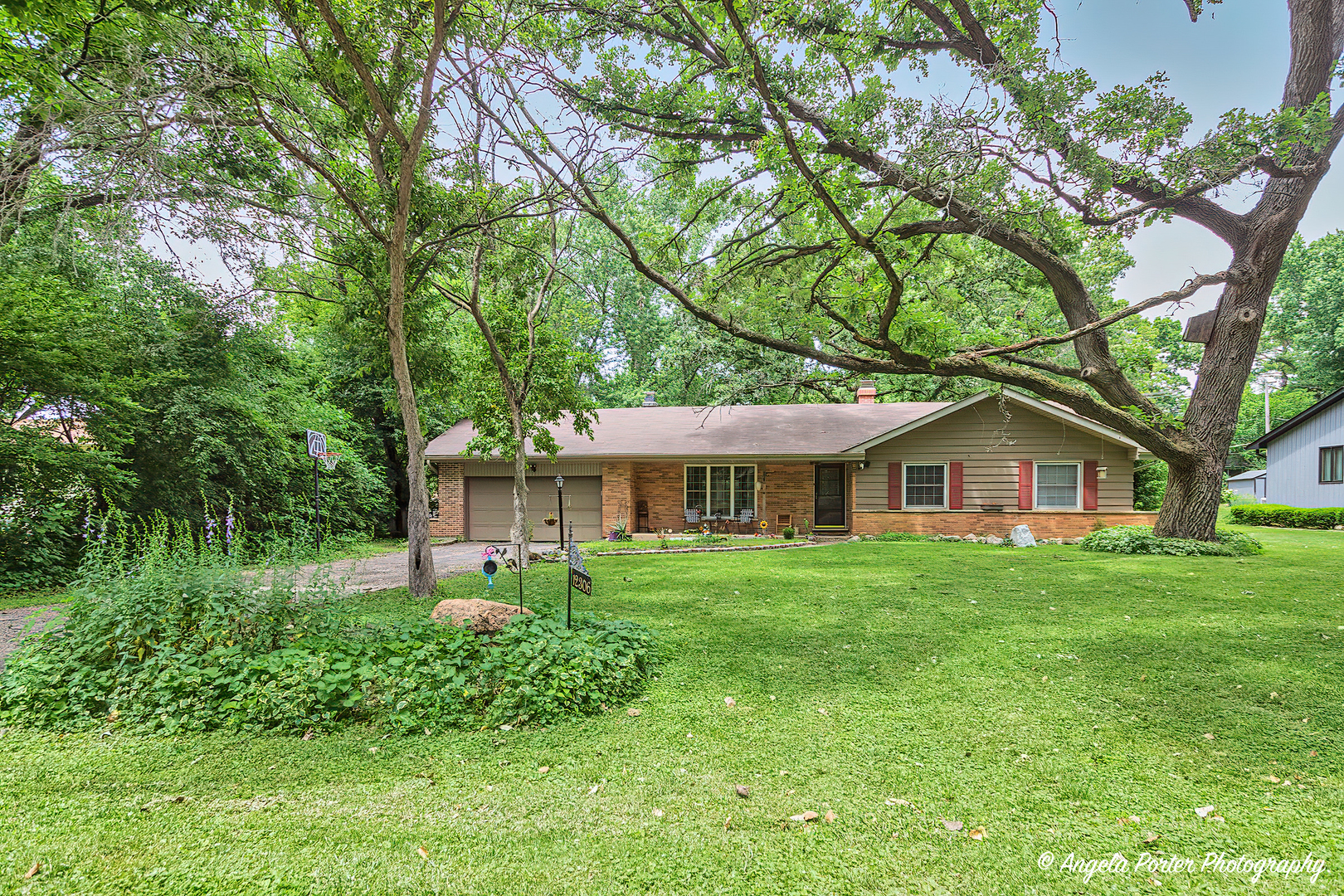 12306 Roger Road Woodstock, IL 60098 - Photo 1 of 20 a front view of a house with a garden
