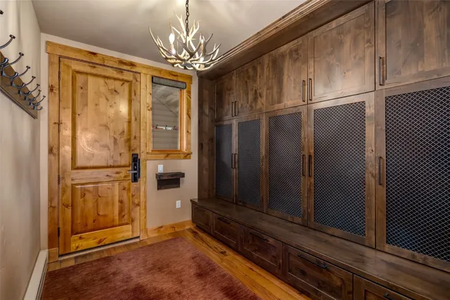 a view of a refrigerator in kitchen and an empty room with wooden floor