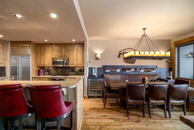 a kitchen with a dining table chairs and refrigerator