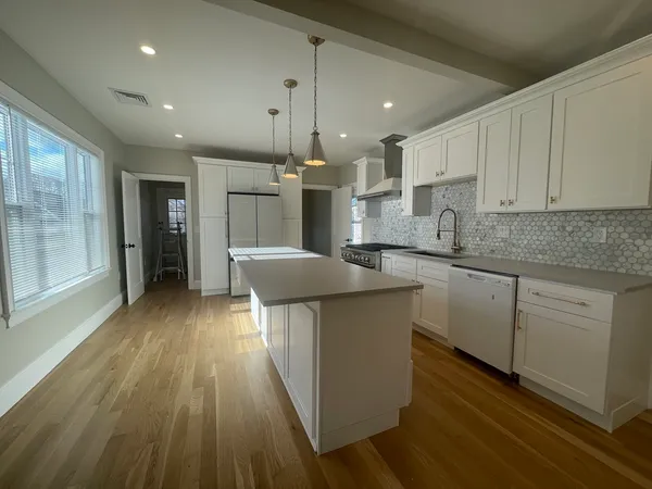 a kitchen with stainless steel appliances granite countertop a sink a stove and a refrigerator