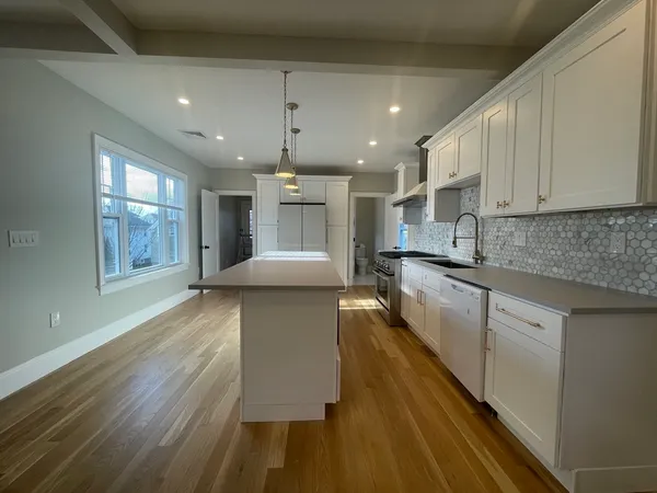 a large kitchen with stainless steel appliances kitchen island a large counter space a sink and a window