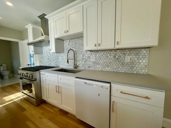 a kitchen with stainless steel appliances granite countertop a sink stove and cabinets