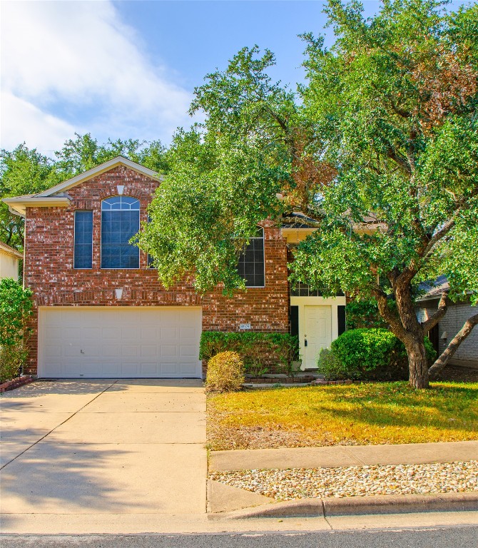 a front view of a house with a yard and trees