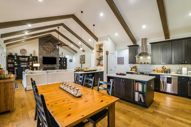 a kitchen with stainless steel appliances granite countertop a sink counter space and living room view