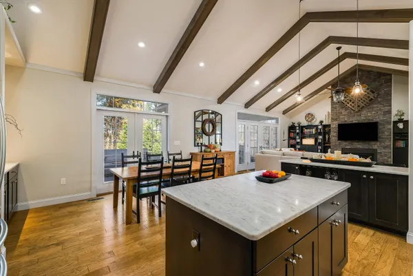 a kitchen with stainless steel appliances granite countertop a sink counter space and living room view