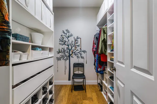 a view of walk in closet with clothes and shoes