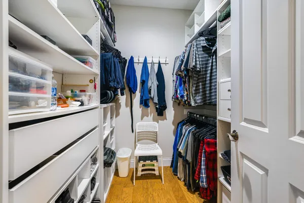 a view of walk in closet with clothes and shoes