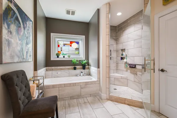 a bathroom with a tub a sink and glass door