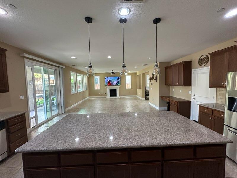 1749 Ettle Street Manteca, CA 95337 - Photo 6 of 12 a view of a kitchen with kitchen island a counter top and stainless steel appliances