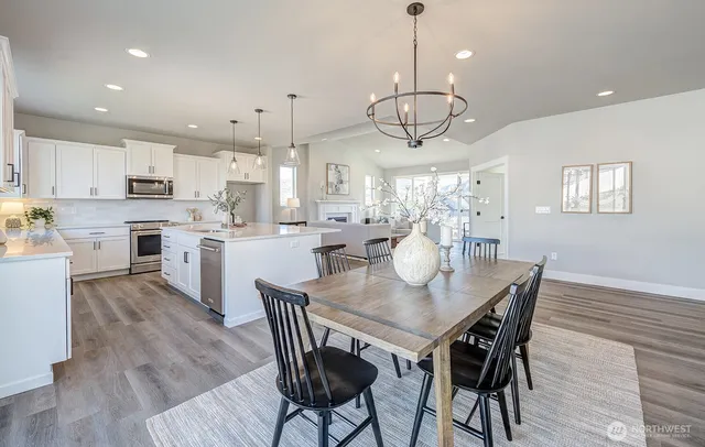 a view of a dining room and livingroom with furniture wooden floor a chandelier