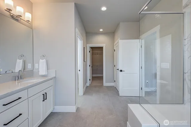 a bathroom with a granite countertop sink a mirror and a shower