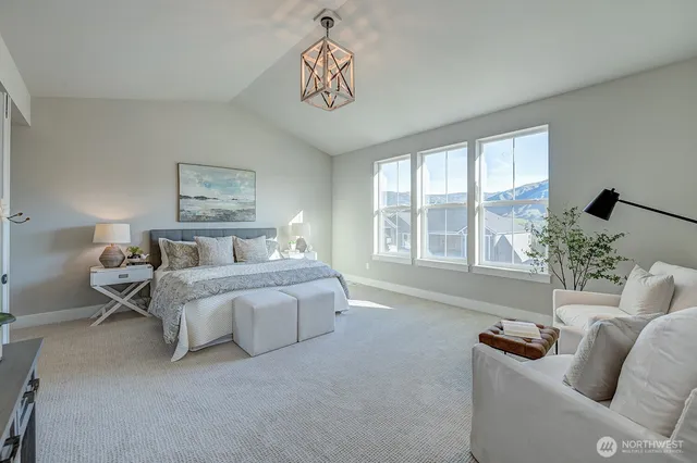 a spacious bedroom with furniture and a large window