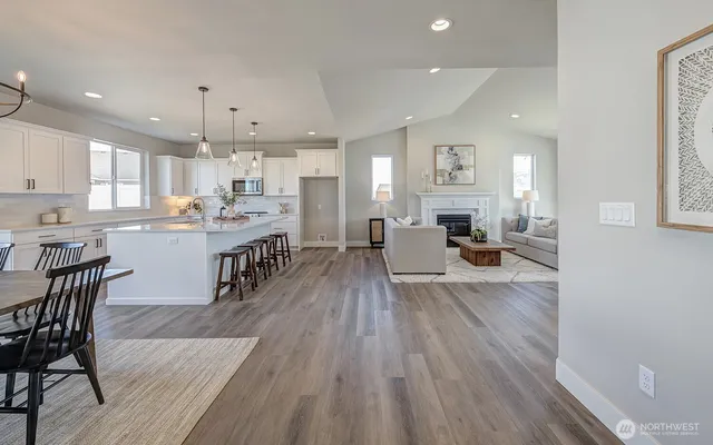 an open kitchen with wooden floor and stainless steel appliances