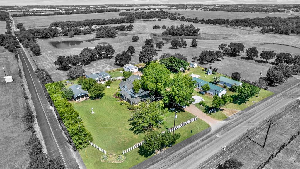 1425 Lone Star Road Celina, TX 75009 - Photo 36 of 40 This aerial view showcases the thoughtful layout of the 2.44-acre estate, where the historic main residence, four income-producing rental cottages, and numerous outdoor amenities come together in one beautifully maintained setting. Mature trees, expansive lawns, a covered pavilion, gazebo, fire pit, and open green space create a private country retreat with exceptional versatility and investment potential.