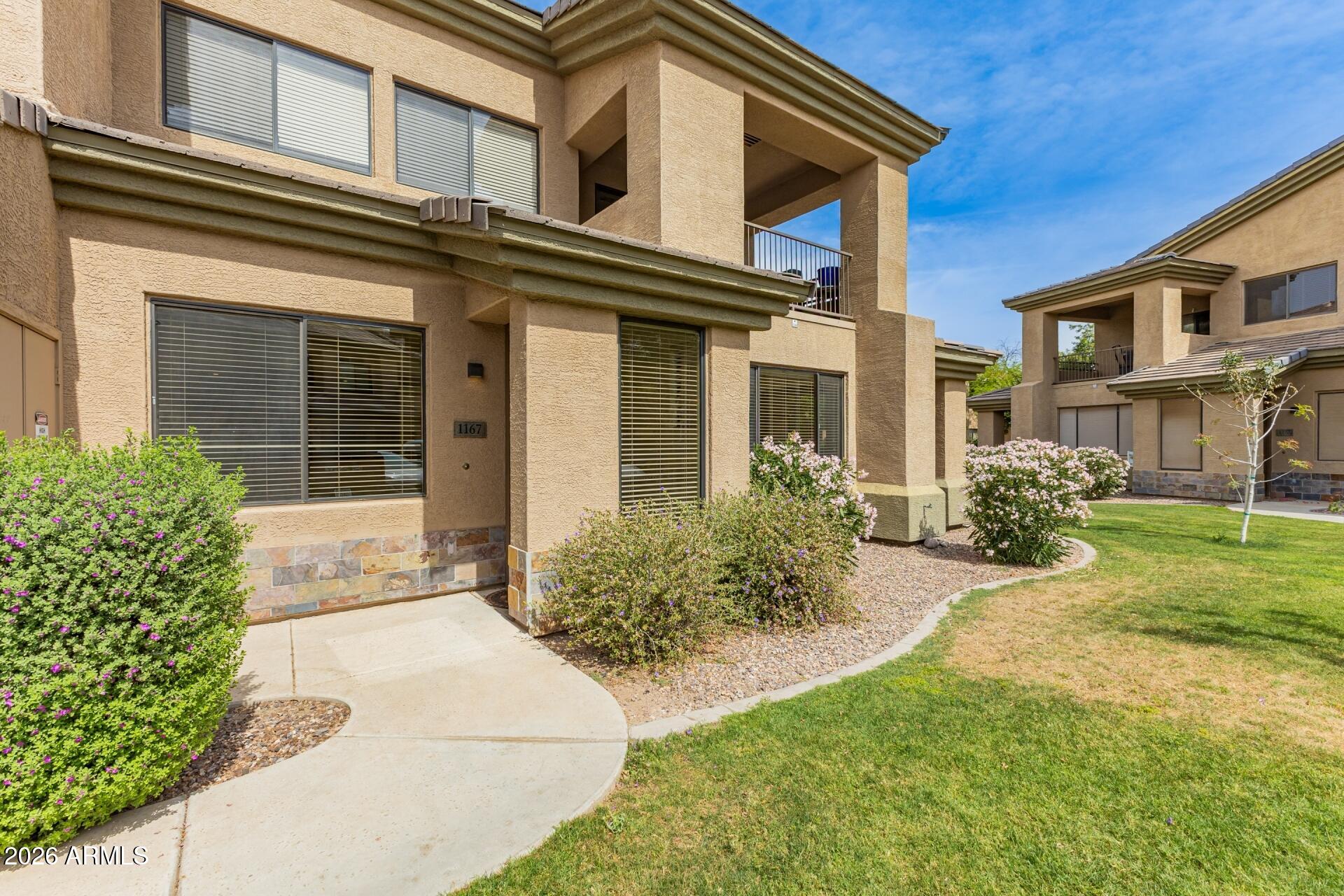 705 West Queen Creek Road, Unit 1167 Chandler, AZ 85248 - Photo 3 of 31 a front view of a house with garden