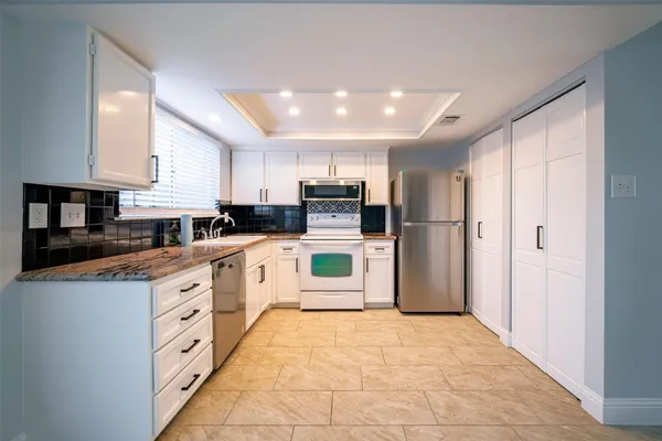 a large kitchen with cabinets and stainless steel appliances