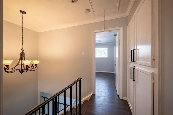 a view of a hallway with wooden floor and stairs