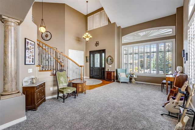 a dining room with furniture and large windows