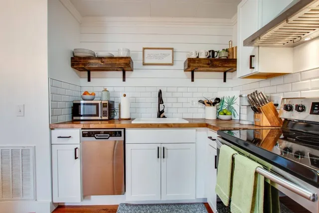 a kitchen with stainless steel appliances a stove a sink and a microwave