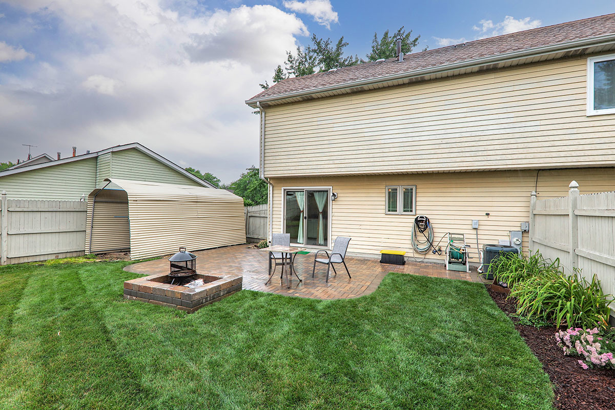 3342 Fox Hill Road Aurora, IL 60504 - Photo 22 of 25 a view of a backyard with table and chairs and potted plants