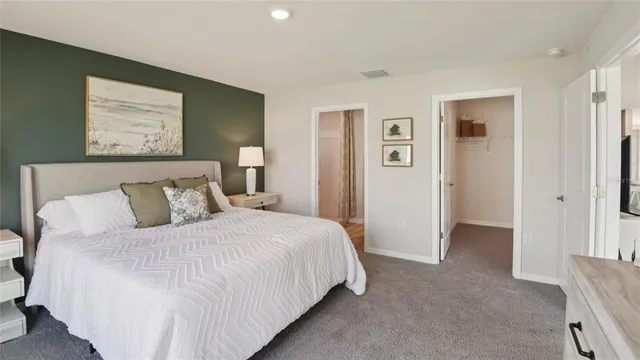 a bedroom with a bed and painting on the wall