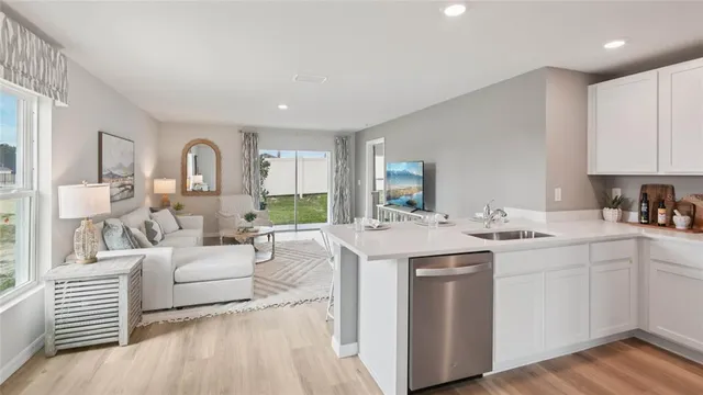 a kitchen with white cabinets and sink