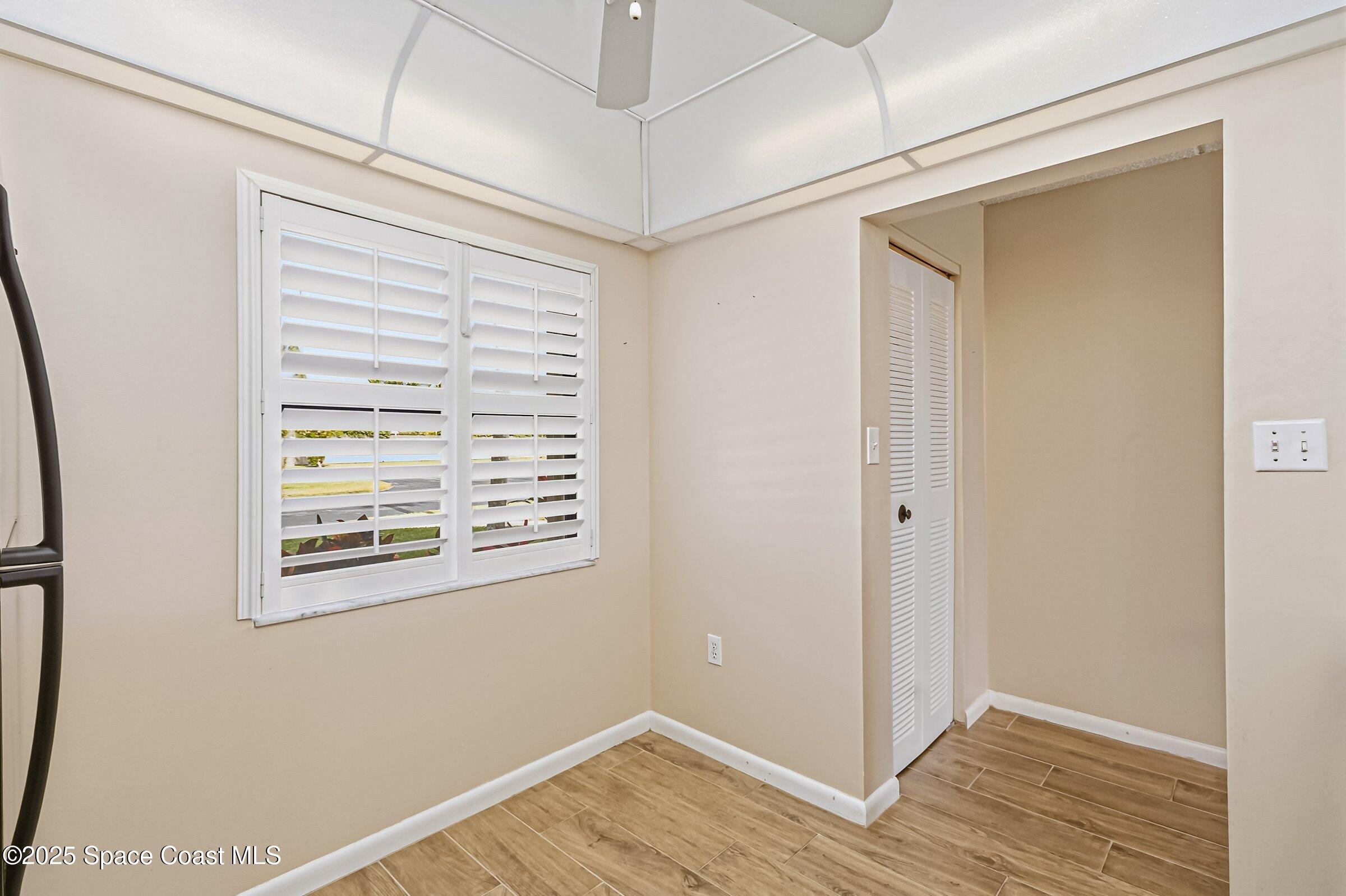 2727 North Wickham Road, Unit 11104 Melbourne, FL 32935 - Photo 11 of 55 a view of an empty room with wooden floor and a window
