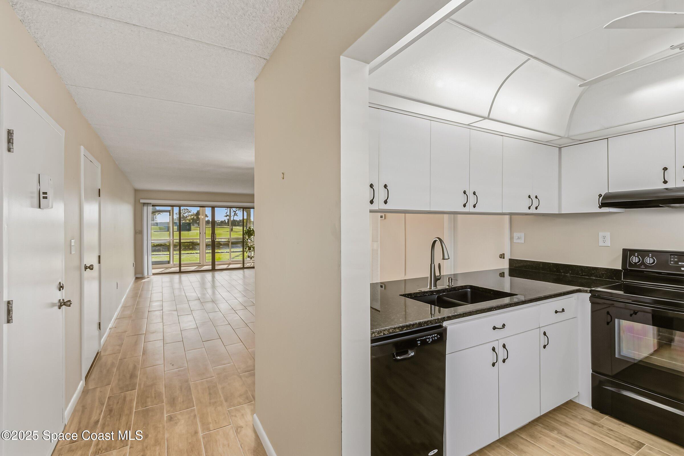 2727 North Wickham Road, Unit 11104 Melbourne, FL 32935 - Photo 13 of 55 a kitchen with granite countertop a stove a sink and a refrigerator