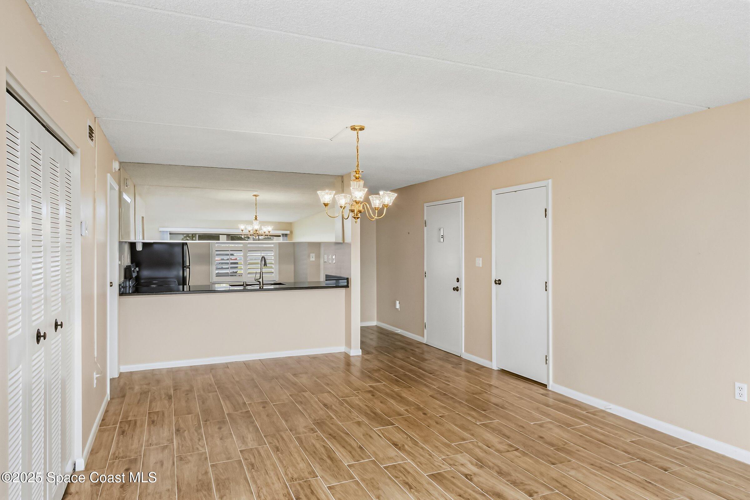 2727 North Wickham Road, Unit 11104 Melbourne, FL 32935 - Photo 14 of 55 a view of a kitchen with refrigerator and wooden floor