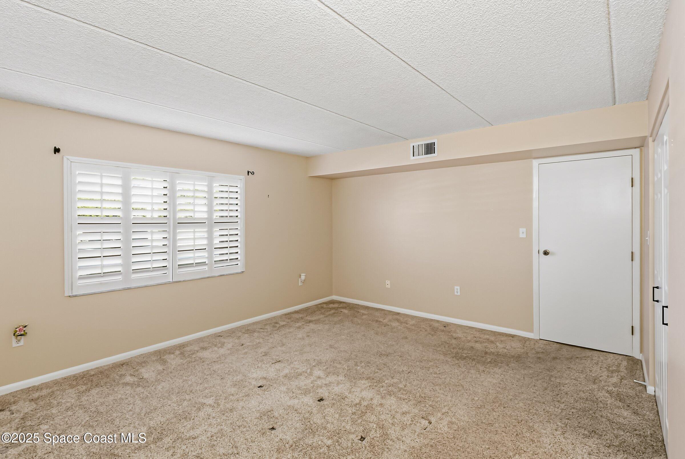 2727 North Wickham Road, Unit 11104 Melbourne, FL 32935 - Photo 19 of 55 a view of an empty room with a window