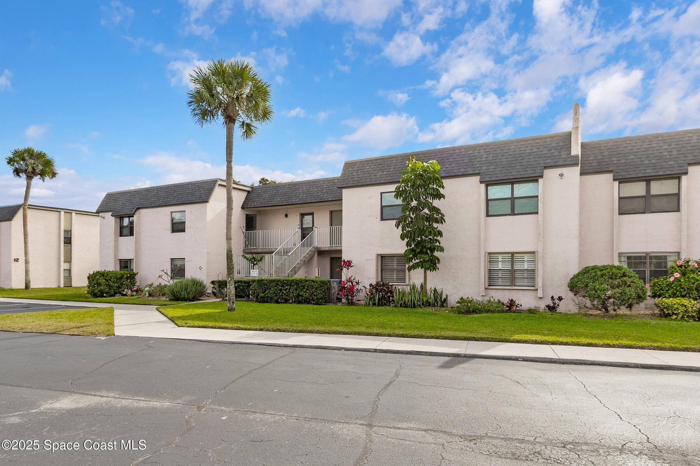 2727 North Wickham Road, Unit 11104 Melbourne, FL 32935 - Photo 4 of 55 a front view of a house with garden and plants