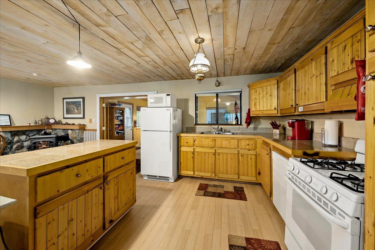 3000 Succor Lane Colfax, CA 95713 - Photo 16 of 56 a kitchen with stainless steel appliances granite countertop a stove a refrigerator a sink dishwasher and white cabinets with wooden floor