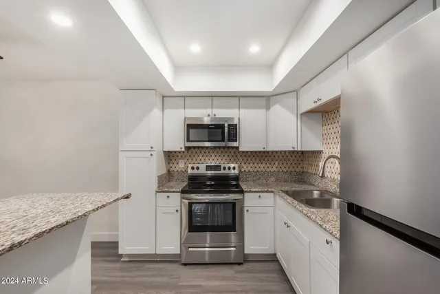a kitchen with a refrigerator sink and cabinets
