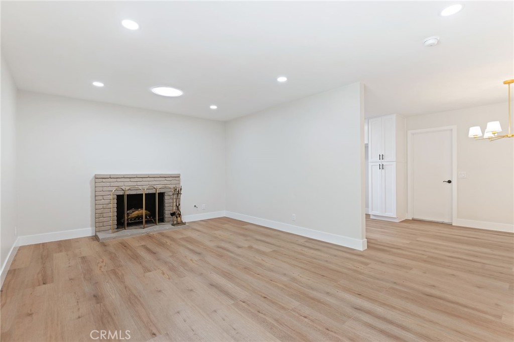 1077 Offshore Street Oxnard, CA 93035 - Photo 14 of 33 an empty room with wooden floor and fireplace