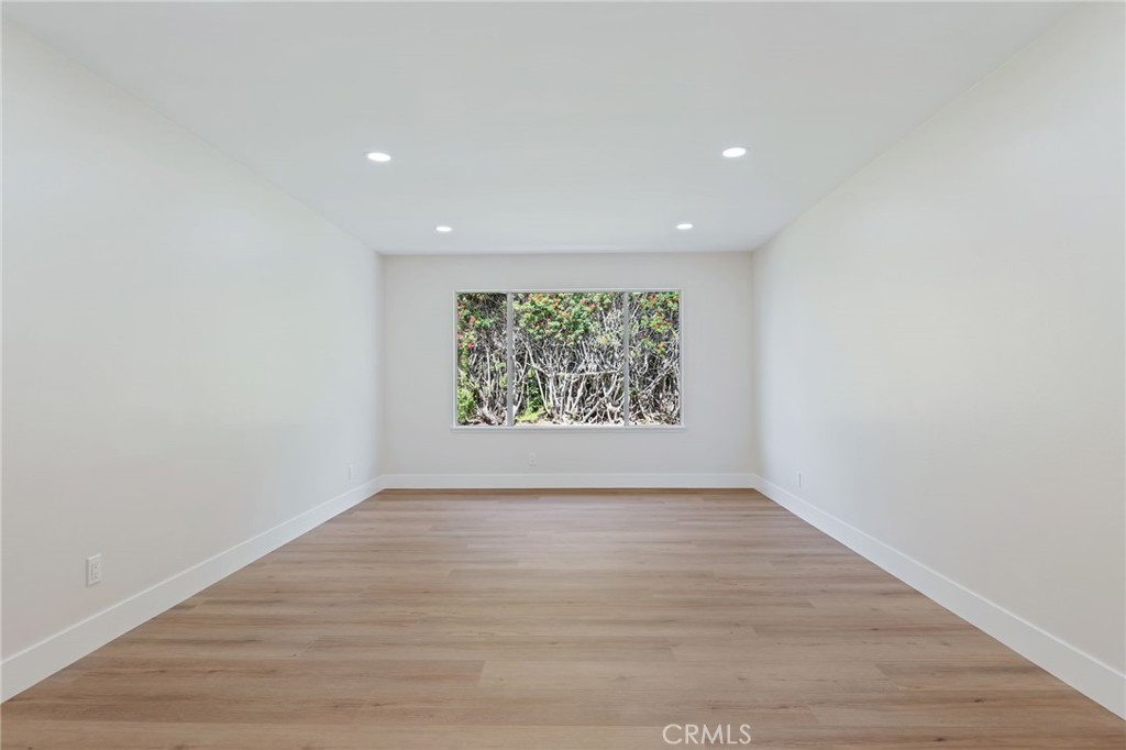 1077 Offshore Street Oxnard, CA 93035 - Photo 16 of 33 a view of an empty room with wooden floor and window