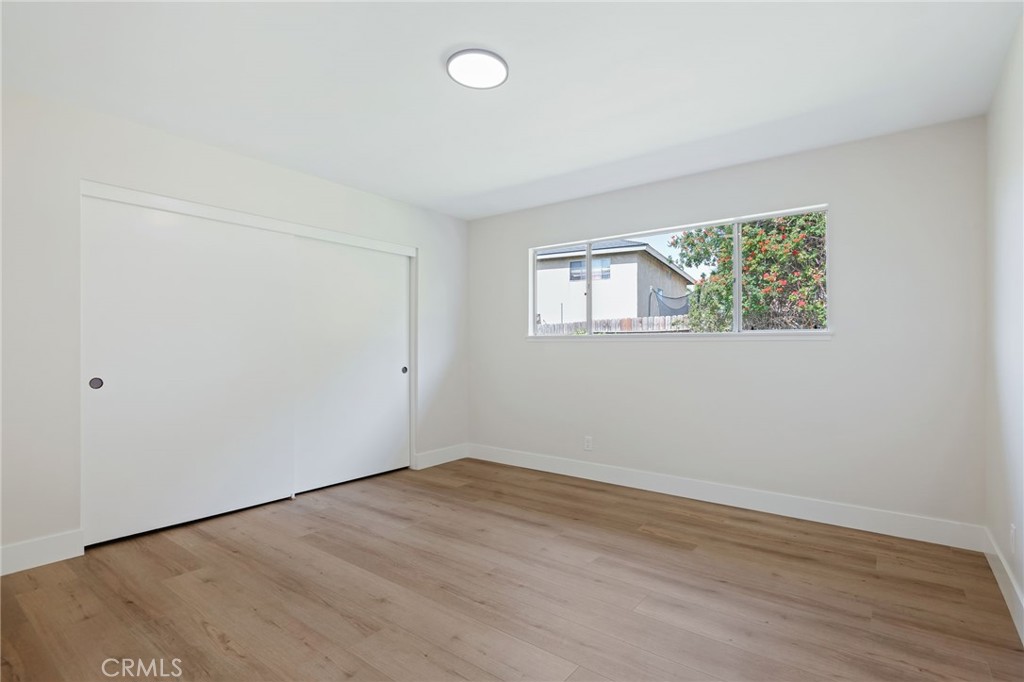 1077 Offshore Street Oxnard, CA 93035 - Photo 21 of 33 an empty room with wooden floor and windows
