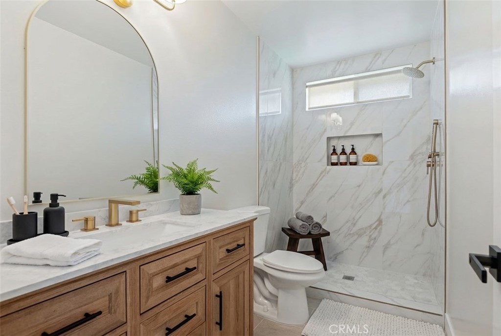 1077 Offshore Street Oxnard, CA 93035 - Photo 26 of 33 a bathroom with a granite countertop sink a toilet and shower