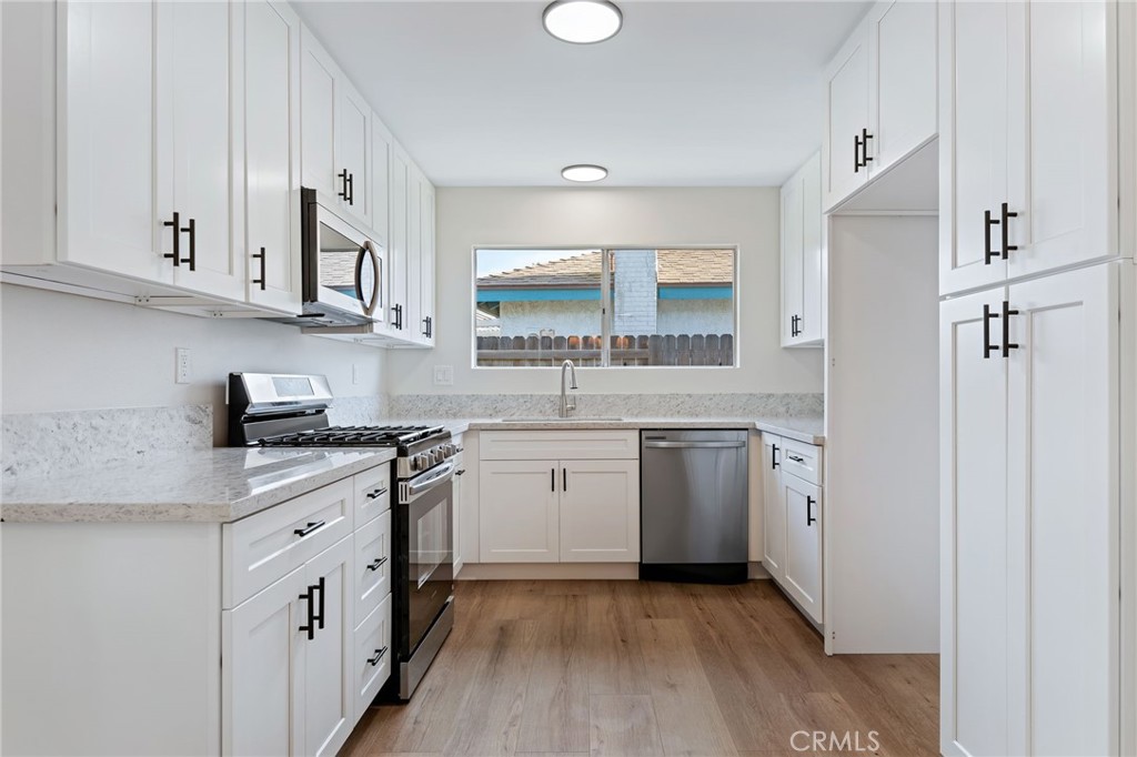 1077 Offshore Street Oxnard, CA 93035 - Photo 7 of 33 a kitchen with cabinets appliances and a sink