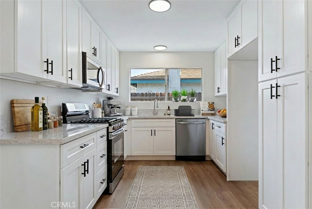 1077 Offshore Street Oxnard, CA 93035 - Photo 8 of 33 a kitchen with white cabinets and white appliances