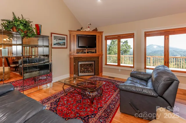 a living room with furniture a flat screen tv and a floor to ceiling window