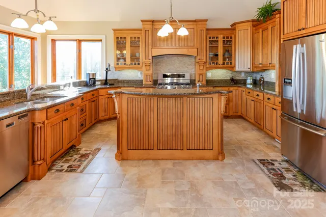 a large kitchen with kitchen island granite countertop a large counter top stainless steel appliances and cabinets