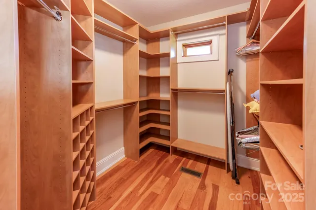 a view of walk in closet with empty racks