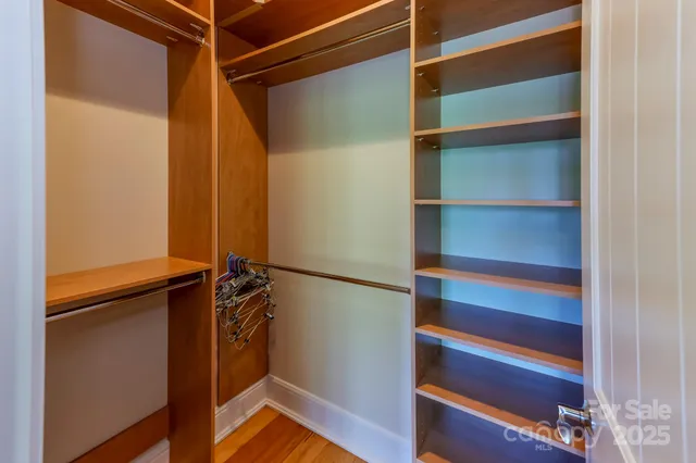 a view of walk in closet with empty racks