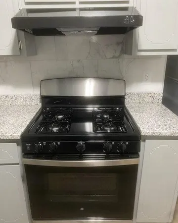 a stove top oven sitting inside of a kitchen