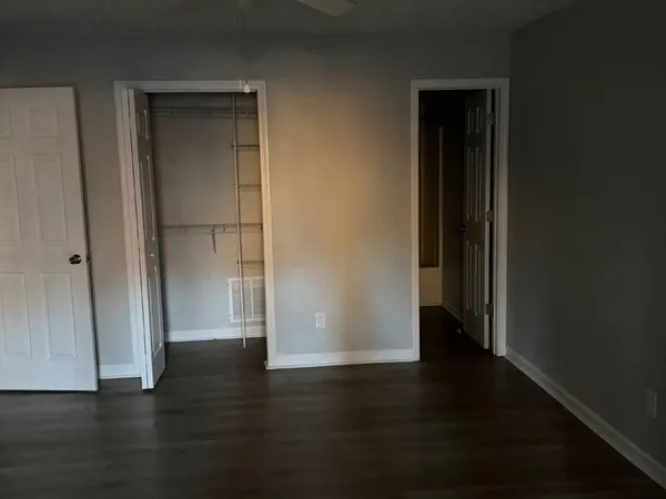 an empty room with wooden floor and closet