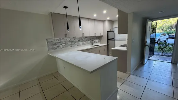 a kitchen with stainless steel appliances granite countertop a sink a stove and a refrigerator