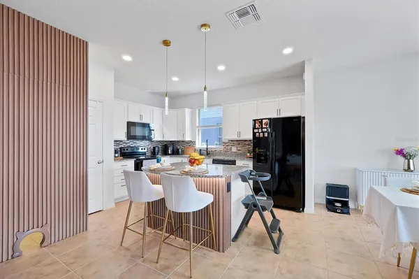 a kitchen with stainless steel appliances kitchen island granite countertop a refrigerator and microwave