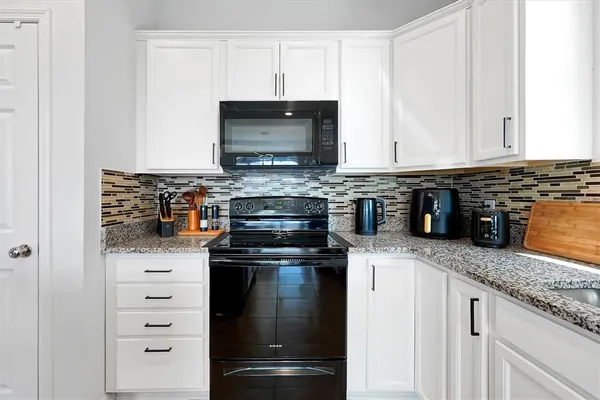 a kitchen with stainless steel appliances granite countertop a stove and a microwave