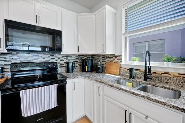 a kitchen with stainless steel appliances granite countertop a sink stove and microwave