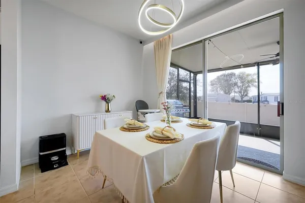 a kitchen with a dining table chairs refrigerator and microwave